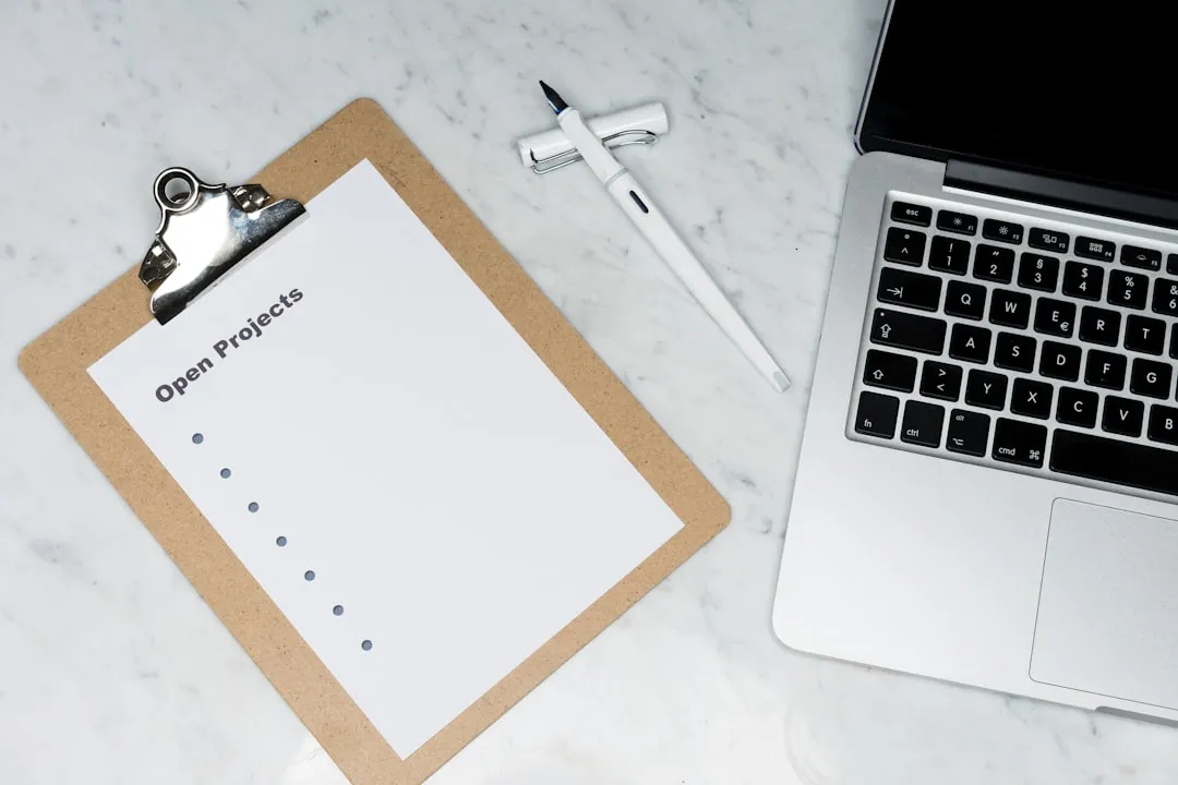 Mesa com celular, currículo impresso e documentos genéricos, sugerindo checklist para iniciar a busca.