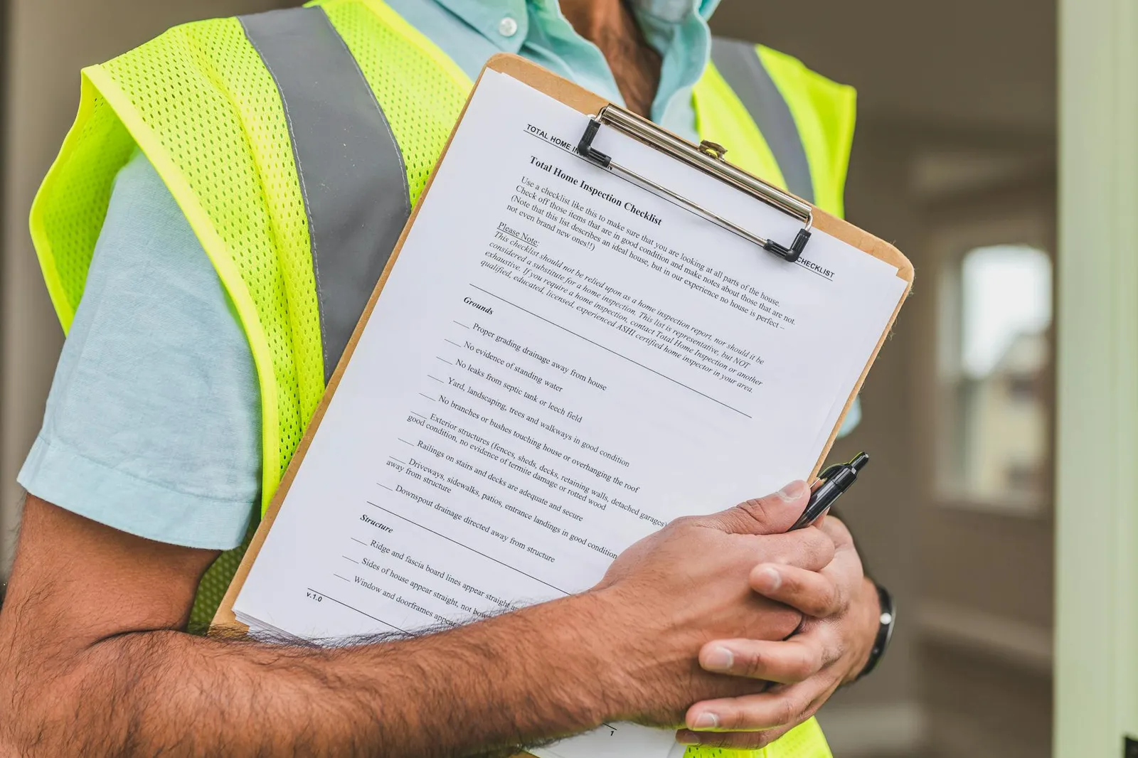 Checklist de revisão e envelope sobre mesa, com smartphone desfocado ao lado.