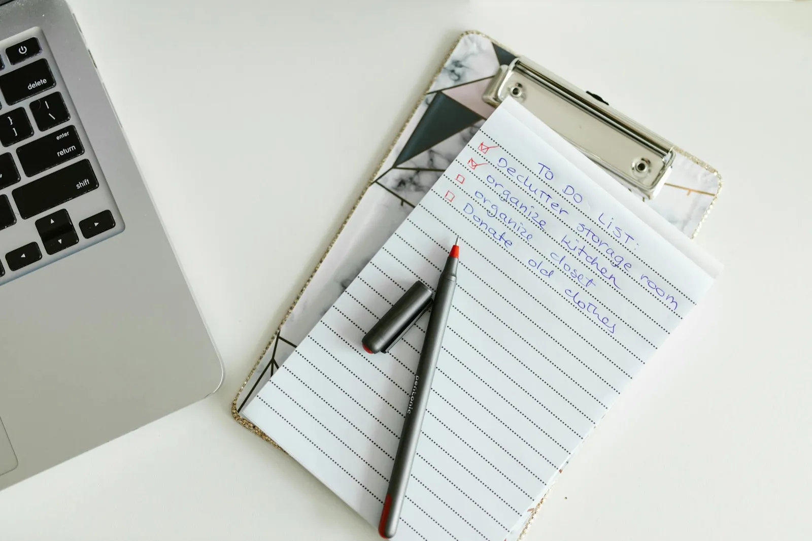 Laptop e checklist em papel com caixas vazias, ambiente organizado, sem texto legível