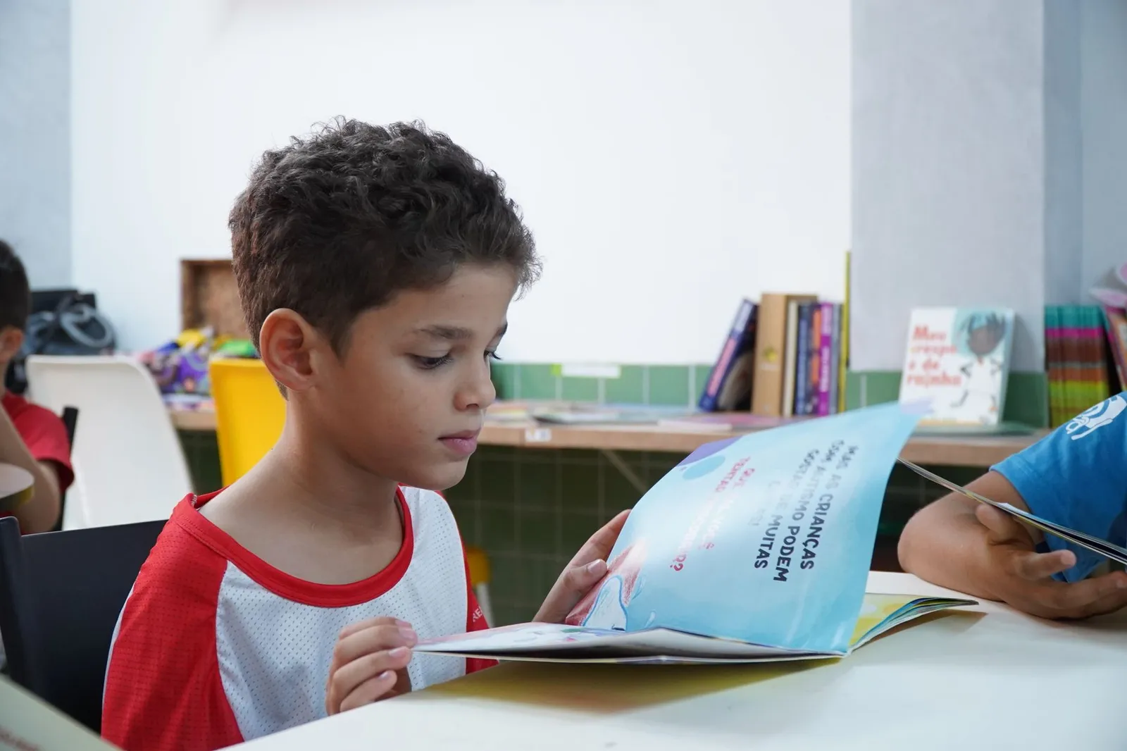 Close de edital aberto com marcador e régua para orientar a leitura por seções.