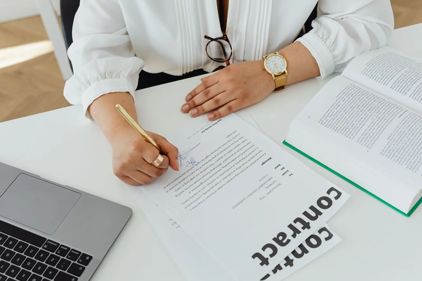 Documentos e pasta sobre mesa, sugerindo contrato de trabalho com CLT